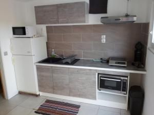 a small kitchen with a sink and a refrigerator at Studios - Bord de Plage in Vias