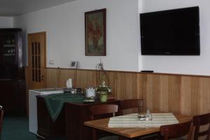 a kitchen with a table and a television on the wall at Ferienhof Koch in Oedelsheim