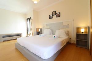 a bedroom with a large white bed with two pillows at BeGuest Cascais INN Apartments_ Ocean View in Alcabideche