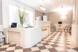 a salon with a reception counter and a checkered floor at Hotel Willa Flora in Szczecin