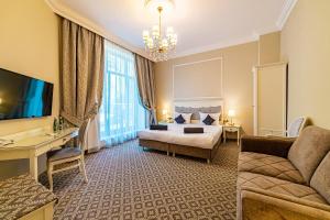 um quarto de hotel com uma cama e um sofá em Hotel Willa Flora em Szczecin