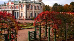 a large house with red flowers in front of it at Villa Kadriorg Hostel in Tallinn