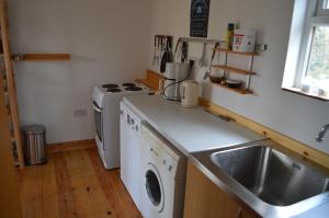 een keuken met een wastafel en een wasmachine bij Barrington Barn in Barrington