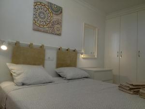 1 dormitorio con 1 cama y una pintura en la pared en Dunatlantico, en Playa del Inglés