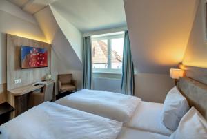 a hotel room with two beds and a window at Pension StromInn in Warnemünde