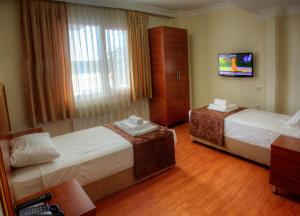 イスタンブールにあるHotel Real Lifeのベッド2台とテレビが備わるホテルルームです。