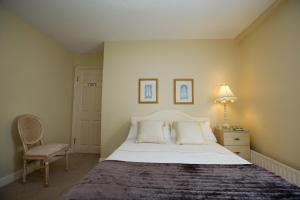 a bedroom with a large bed and a chair at Griffin Lodge Guesthouse in Galway