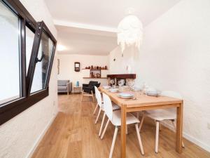 a dining room with a wooden table and white chairs at Holiday Home Paris by Interhome in Calonge