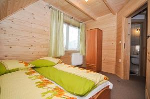 a bedroom with a large bed in a wooden room at Domki u Wilka in Poronin