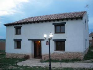 una casa bianca con un lampione davanti di Tierras de Aguilera a Aguilera