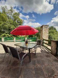 a table with a red umbrella on a patio at Plantagengut Hosterwitz in Dresden