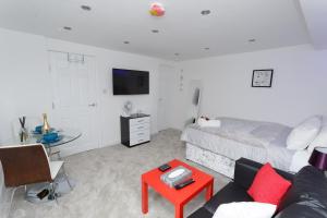 ein Wohnzimmer mit einem Bett und einem roten Tisch in der Unterkunft Clifton Bespoke Serviced Apartments in Leeds