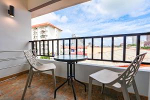 balcón con mesa y sillas y vistas a la playa en Nalanta Hotel Pattaya en Pattaya centro