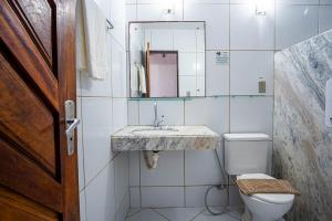 La salle de bains est pourvue d'un lavabo et de toilettes. dans l'établissement Pousada Villa do Sol, à Genipabu