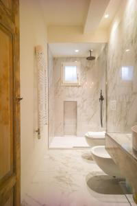 a bathroom with two sinks and two toilets and a shower at Luxury Apartment in Palazzo Spada in Bologna