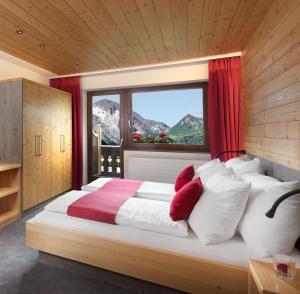 - une chambre avec un grand lit et une fenêtre dans l'établissement Hotel Höhlenstein, à Tux