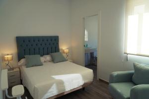 Un dormitorio con una cama grande y un sofá. en Apartamentos Ondeanos, en La Carolina