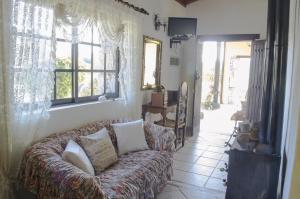 Una sala de estar con un sofá y una ventana. en Vivelorural casa en Valle de Chira con piscina, en San Bartolomé