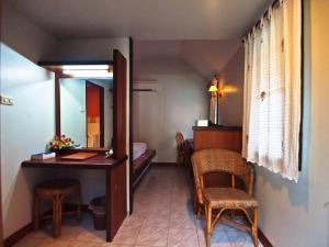 a room with a vanity and a mirror and a table and chairs at P.P. Casita - Adult Only in Phi Phi Don