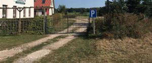 una puerta con una señal de estacionamiento junto a una carretera en Hotel Kranichblick, en Kluis