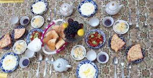 a table topped with blue and white plates of food at Bobo Haydar Guest House in Bukhara