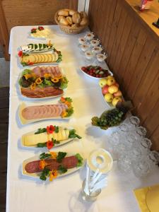 a long table with many plates of food on it at Hotel Kranichblick in Kluis