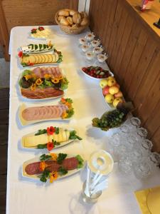ein langer Tisch mit vielen Teller Essen drauf in der Unterkunft Hotel Kranichblick in Kluis