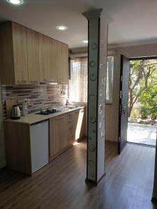 - une cuisine avec des placards en bois et un comptoir dans l'établissement Comfort, à Tbilissi