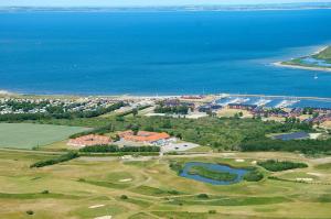 an aerial view of a golf course next to the ocean at HotelVFjorden in Lemvig