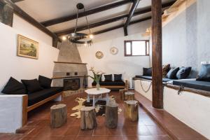ein Wohnzimmer mit einem Sofa und einem Tisch und einigen Holzscheiten in der Unterkunft Casa el Refugio de Arucas in Arucas