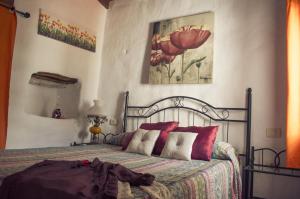 a bedroom with a bed with red pillows at Vivelorural casa Tunte 1, piscina y terraza in San Bartolomé de Tirajana