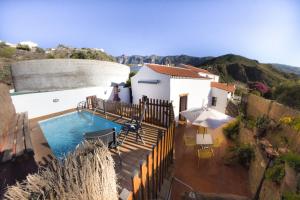 a house with a swimming pool next to a building at Vivelorural casa Tunte 1, piscina y terraza in San Bartolomé de Tirajana