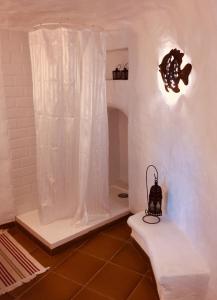 a bathroom with a shower with a white shower curtain at La Cuevita in Santa Brígida