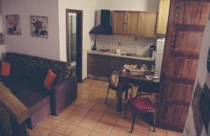 a kitchen with a couch and a table in a room at Vivelorural Casa Tunte 2, BBQ y terraza in San Bartolomé de Tirajana