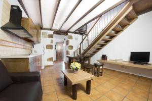 eine Küche und ein Wohnzimmer mit einem Sofa und einem Tisch in der Unterkunft Casa rural en Hoya de Tunte 3 in San Bartolomé de Tirajana