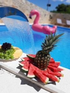 eine Ananas auf einem Teller neben einem Pool in der Unterkunft House Sidro, Stari Grad in Stari Grad
