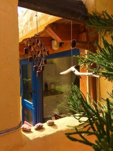 a window with a mannequin hanging from a building at Vivelorural casa La Cuevita, Santa Brígida in Santa Brígida