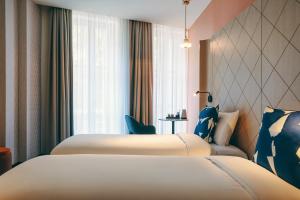 a hotel room with two beds and a window at Mercure Marseille Canebière Vieux-Port in Marseille +118 photos