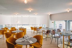 a restaurant with tables and chairs and windows at Mercure Marseille Canebière Vieux-Port in Marseille