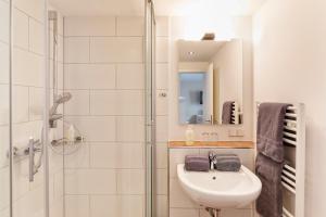 a white bathroom with a sink and a shower at Hotel Helgolandia in Helgoland