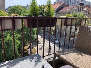 een balkon met een bank en uitzicht op een straat bij Roseman - Small open flat in the city centre in Ljubljana