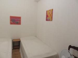 een kleine kamer met een bed en twee foto's aan de muur bij Residence de la Rasclose in Sorède