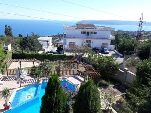 a villa with a swimming pool in front of a house at Vacation Home Seadream in Varna City