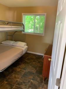 a small room with a bunk bed and a window at Wu Wu's Cabins in Wasaga Beach