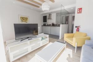 sala de estar con TV de pantalla plana grande en Slow León Apartamentos Turísticos, en León