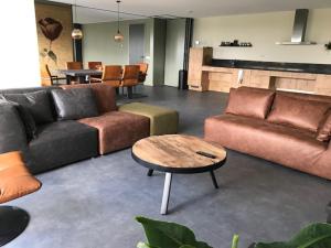 a living room with two couches and a coffee table at Hoeve Oude Tol in Zuidzande