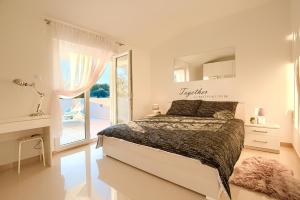 una camera da letto bianca con un letto e uno specchio di LAMALU a Ližnjan (Lisignano)