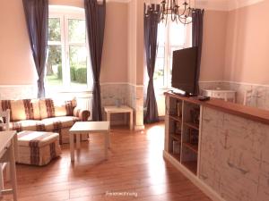a living room with a couch and a tv at Landhotel Gut Zarrentin in Gransebieth