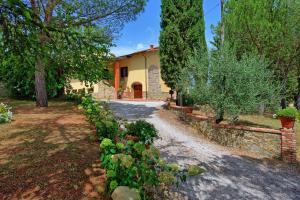 une maison avec un jardin et une allée dans l'établissement Villa Gloria by PosarelliVillas, à Lucignano