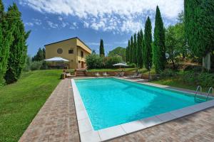 una piscina in un cortile con una casa di Villa Gloria by PosarelliVillas a Lucignano